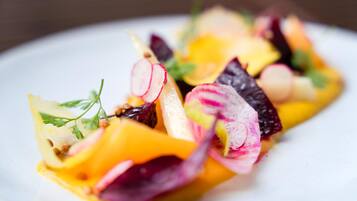 A close-up of a colorful dish with various vegetables and herbs.