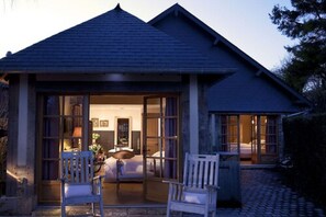A house with a covered porch, a bed, and a dining area.