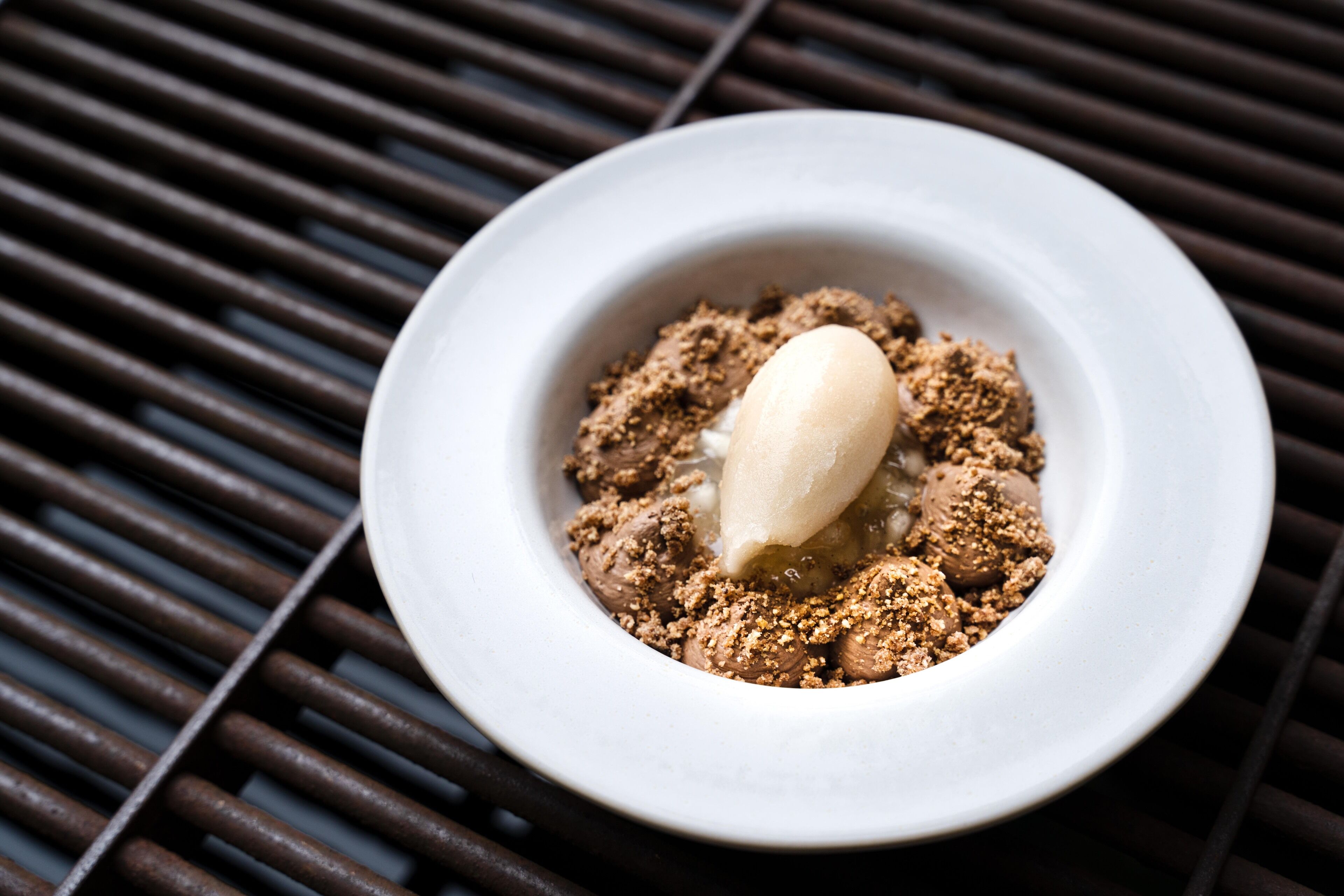 Ein Dessert mit Eis und Schokoladenstreuseln auf einem weißen Teller.