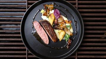 A plate of food with a steak, potatoes, and vegetables.