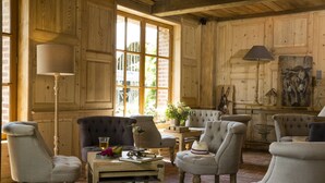 Una habitación acogedora con paneles de madera, asientos cómodos y un ventanal grande.