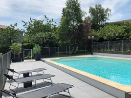 Una piscina al aire libre, sillones reclinables de piscina
