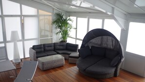 A sunlit room with a curved sofa, a small table, and a potted plant. - Spunta Di Mare (Ajaccio)