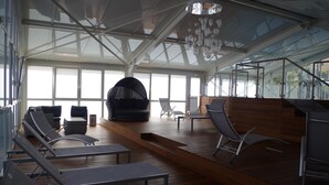 A spacious indoor area with a high ceiling, modern seating, and a staircase leading to an upper level. - Spunta Di Mare (Ajaccio)