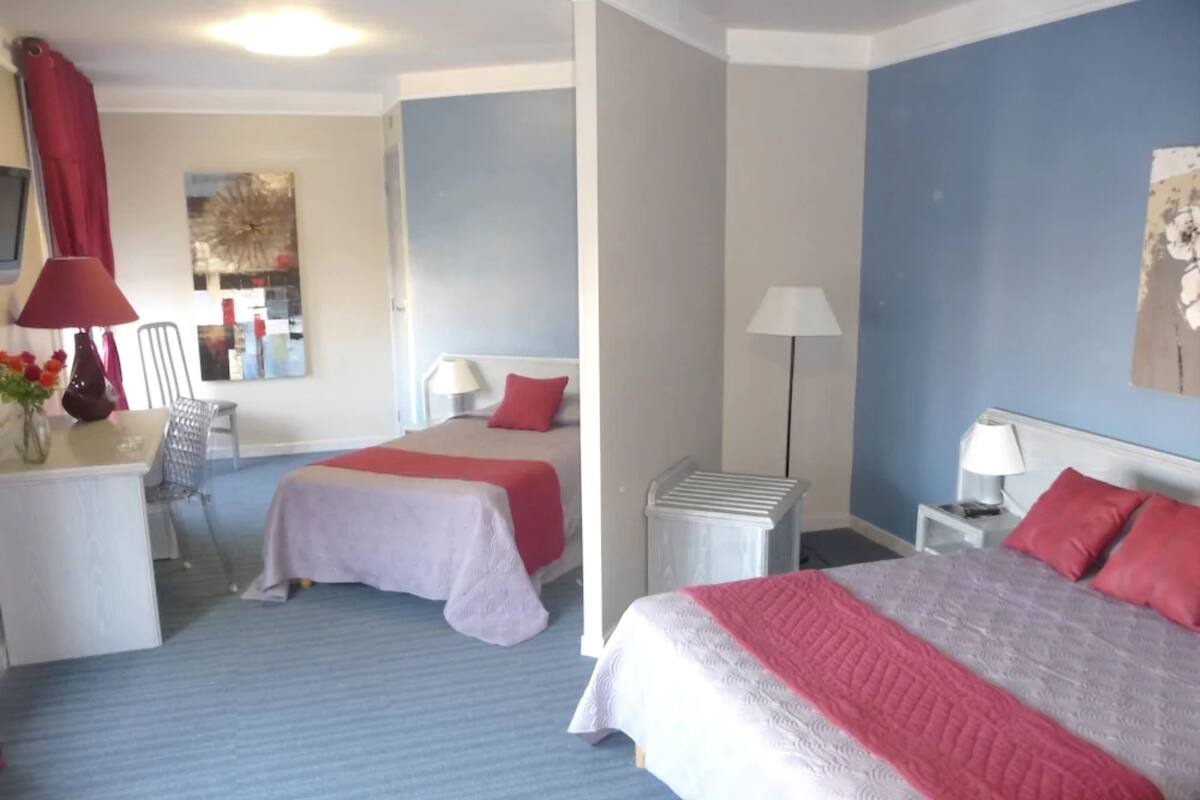 Ein Hotelzimmer mit zwei Betten, einem Schreibtisch und einem Stuhl.