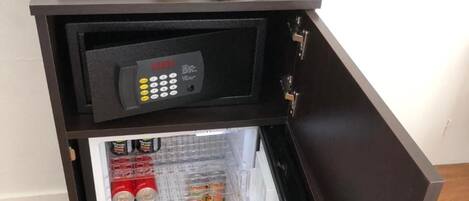 A compact minibar with a coffee maker, a small refrigerator stocked with beverages, and a microwave.