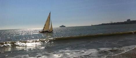 A sailboat on calm waters with a clear sky.