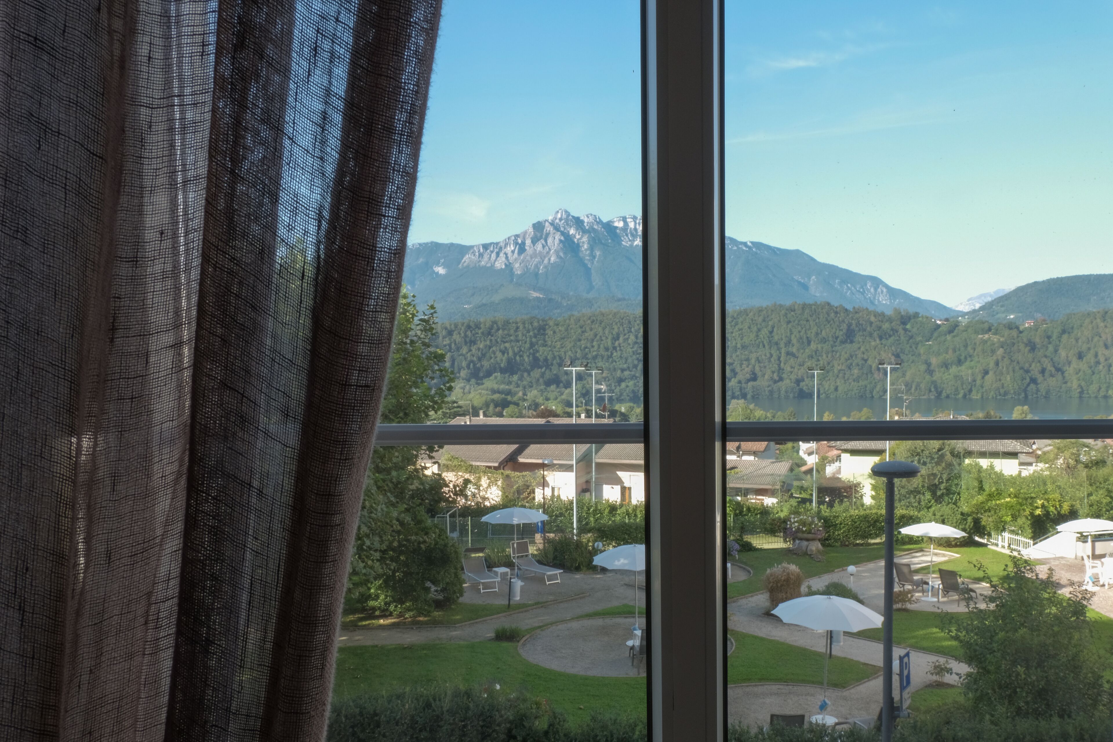 A view from a window overlooking a mountainous landscape with a clear sky.