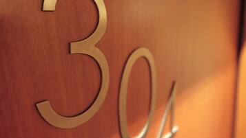 A close-up of a wooden wall with the numbers "30" and "34" cut out, indicating room numbers.