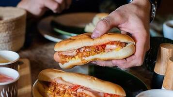 Una persona sosteniendo un sándwich con abundante relleno.