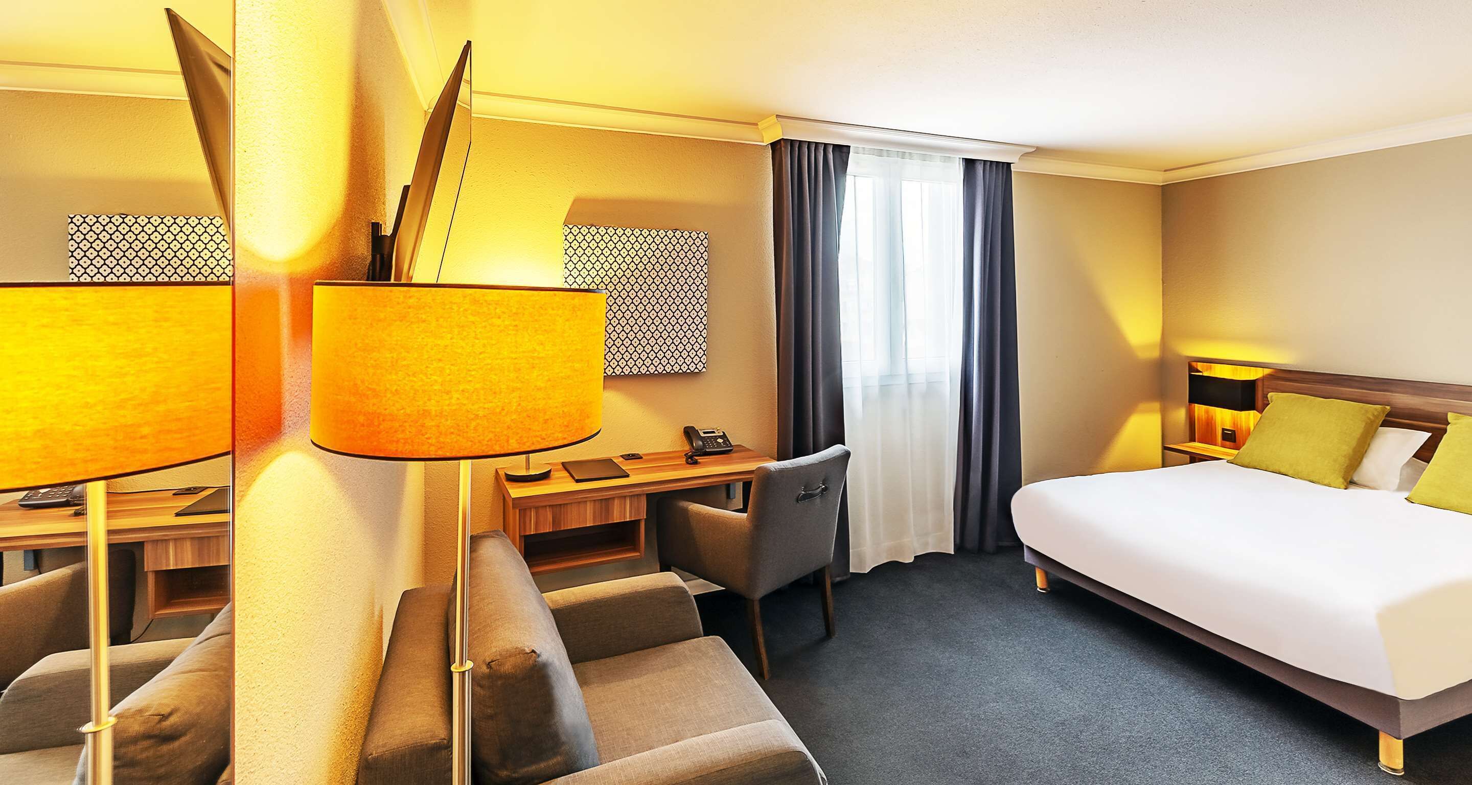 Una habitación de hotel con cama, escritorio y zona de estar.
