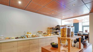 A breakfast bar with various food items and a coffee machine.