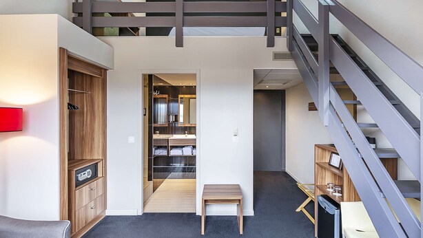 A modern interior with a wooden cabinet, a bench, and a staircase.