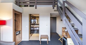 A modern interior with a wooden cabinet, a bench, and a staircase.
