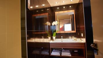 Un baño moderno con un espejo grande, un lavabo y un perchero para toallas.