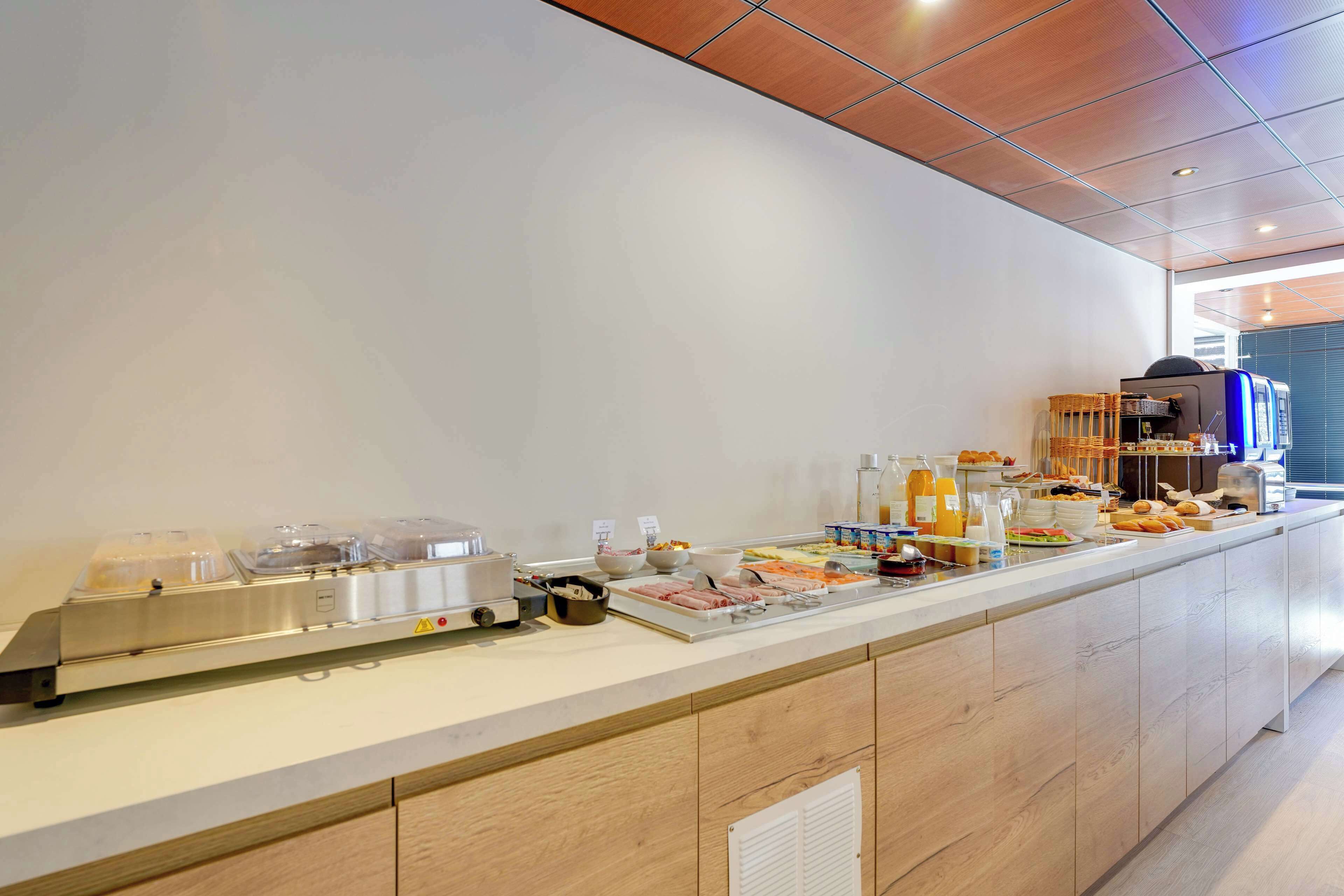 A buffet setup with various food items and a coffee machine.