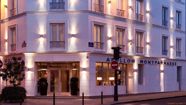 Un hotel a più piani con finestre e balconi illuminati, caratterizzato da uno stile architettonico classico.