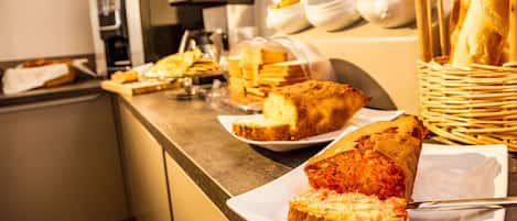 A buffet counter with various baked goods and a coffee machine.