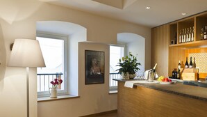 A modern kitchen with wooden cabinetry, a bar area, and a potted plant. - Romanda (Levico Terme)