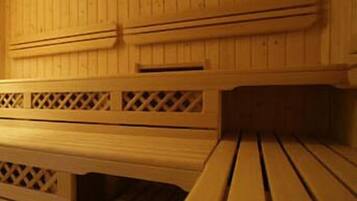 A wooden sauna with benches and a lattice design on the walls.