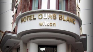 The entrance to HOTEL OURS BLANC with a prominent sign above the door. - Ours Blanc-Wilson (Toulouse)