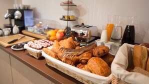 A buffet with various food items including pastries, fruits, and beverages. - Ours Blanc-Wilson (Toulouse)