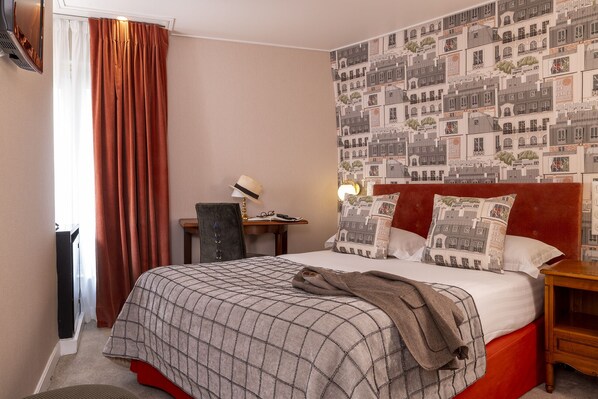 A hotel room with a bed, a nightstand, a desk, and a chair. - Le Regent (Paris)