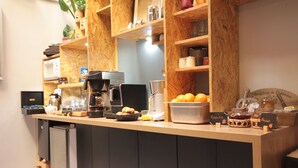 Una cocina con estantes de madera, una cafetera, un microondas y diversos alimentos.