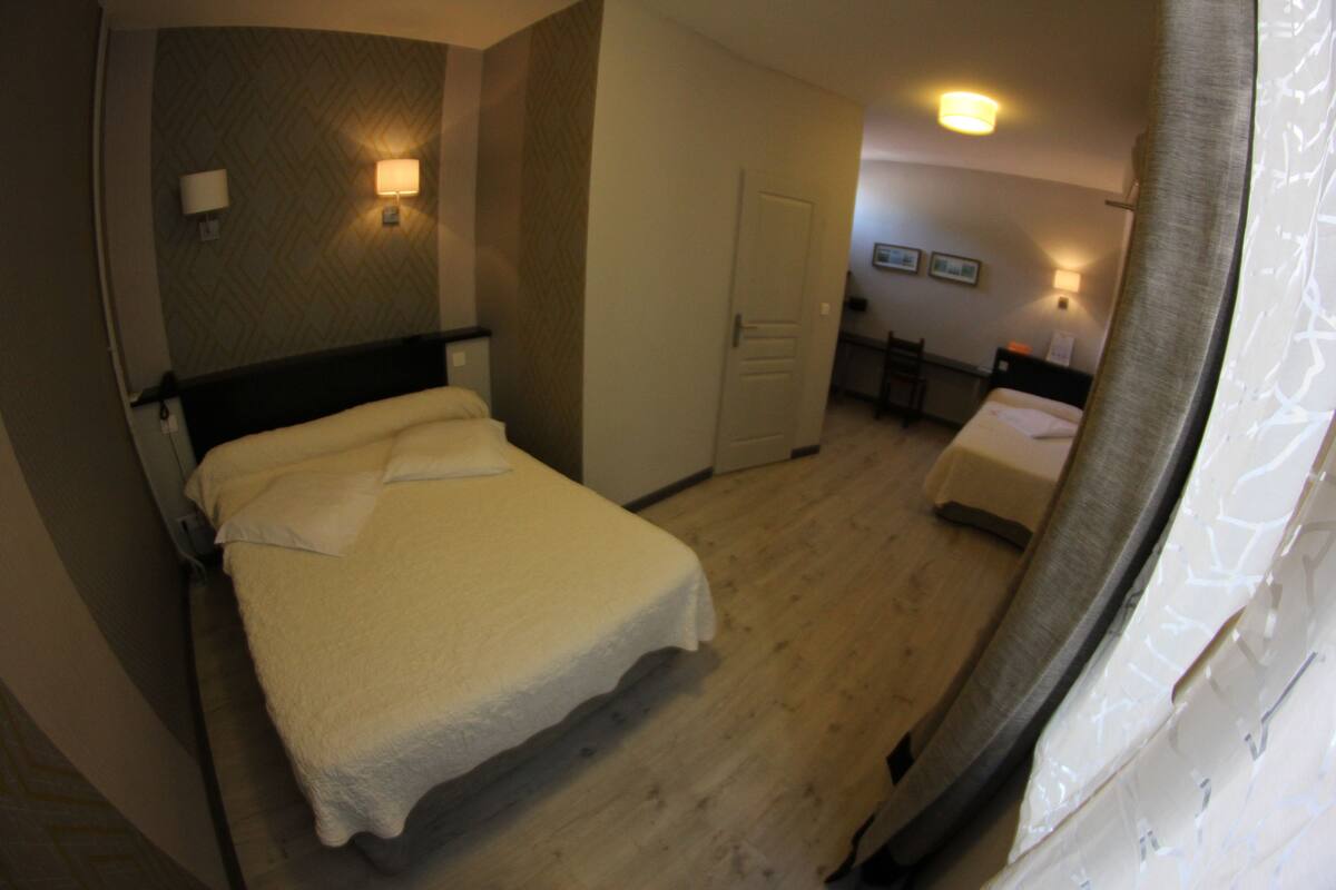 Una habitación de hotel con cama, escritorio y silla.