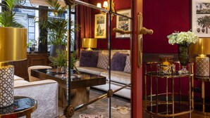 A luxurious living room with a sofa, coffee table, and decorative lamps. - Hotel de Seine (Paris)