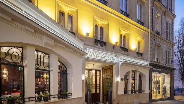 A hotel facade with a classic European architectural style, featuring arched windows and a prominent entrance. - Hotel de Seine (Paris)