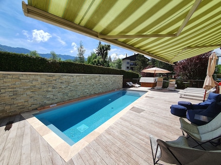Una piscina al aire libre de temporada, sombrillas
