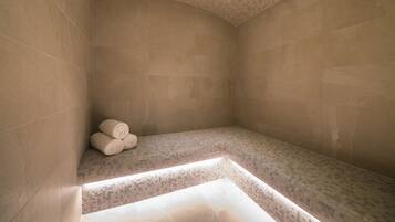 Bathroom features a bench with towels and a mosaic ceiling.