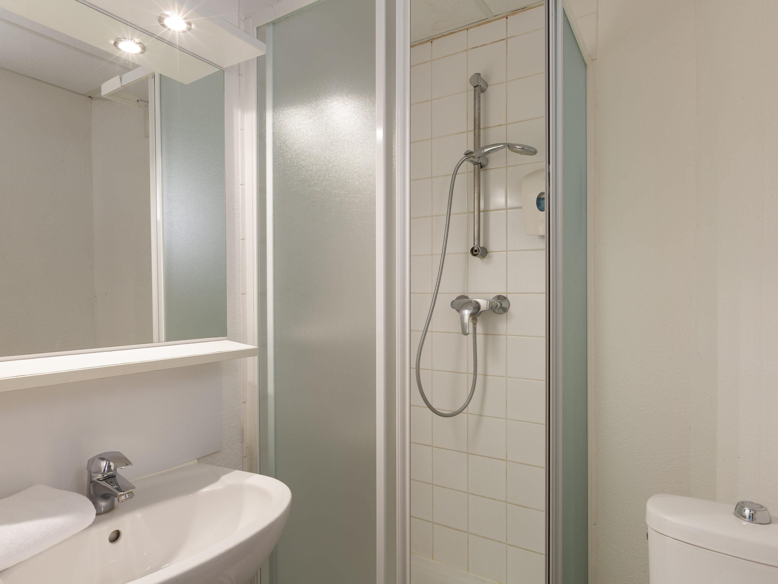 A bathroom with a shower, sink, and toilet.