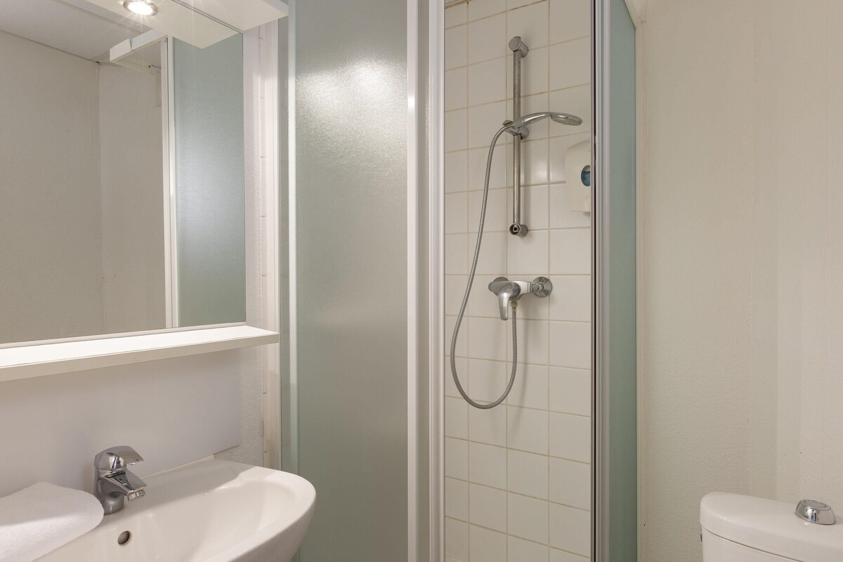 A bathroom with a shower, sink, and toilet.