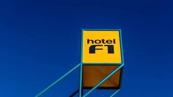 Un letrero amarillo con la palabra 'hotel' y 'FT' sobre un fondo azul.