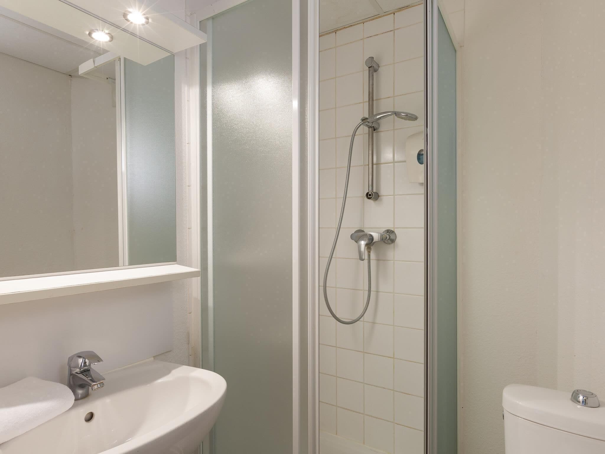 Un baño con ducha, lavabo e inodoro.