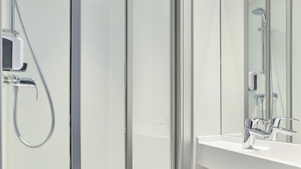 A modern bathroom with a glass shower enclosure, a white sink, and a mirror. - hotelF1 Reims Tinqueux (Tinqueux)