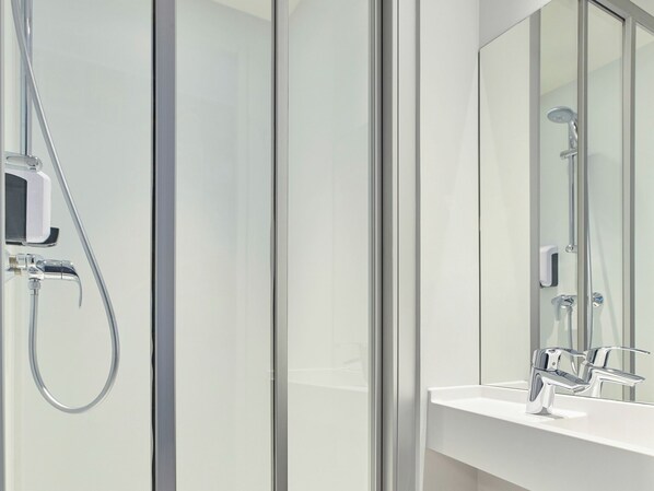 A modern bathroom with a glass shower enclosure, a white sink, and a mirror. - hotelF1 Reims Tinqueux (Tinqueux)