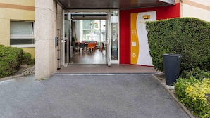 A hotel entrance with a glass door, a reception desk, and a signboard. - hotelF1 Reims Tinqueux (Tinqueux)