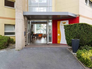 A hotel entrance with a glass door, a reception desk, and a signboard. - hotelF1 Reims Tinqueux (Tinqueux)