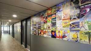 A corridor with a wall decorated with travel posters. - hotelF1 Reims Tinqueux (Tinqueux)