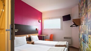 A hotel room with two beds, a window, a TV, and a wall with posters. - hotelF1 Reims Tinqueux (Tinqueux)