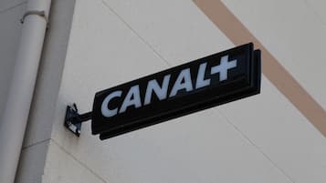 A sign with the word "CANAL+" mounted on a building.