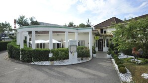 A circular building with a white exterior and green trim, labeled as a restaurant and accommodation. - Cottage Hotel (Vandœuvre-lès-Nancy)