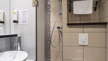 Un baño moderno con un lavamanos grande, inodoro y ducha.