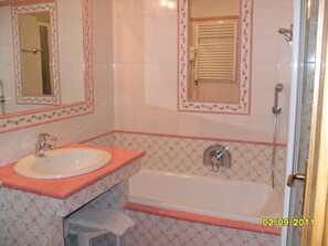 A bathroom with a sink, mirror, and bathtub. - Dahu (Pinzolo)
