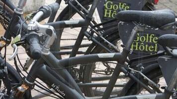 A bicycle with a sign that reads "Prêt par Golf Hôtel".