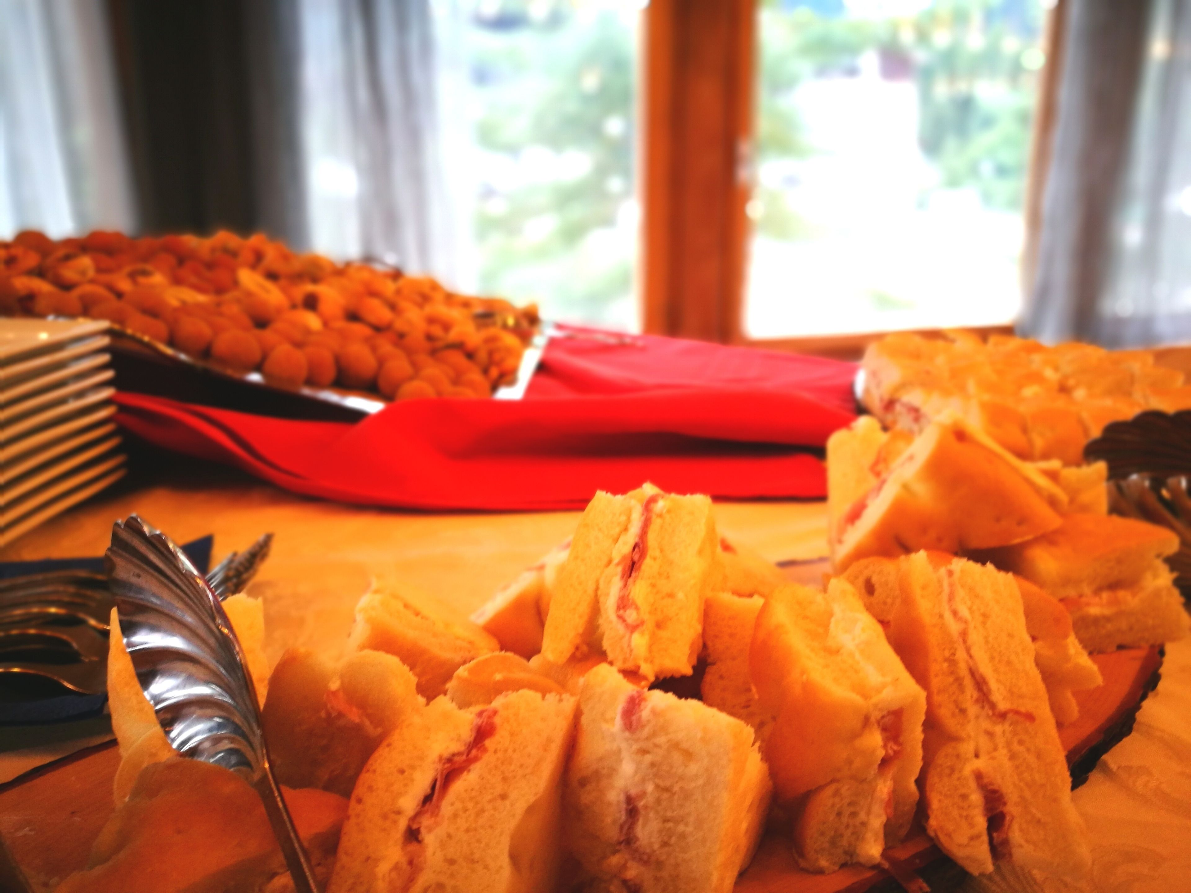 A table with sandwiches and a tray of snacks.