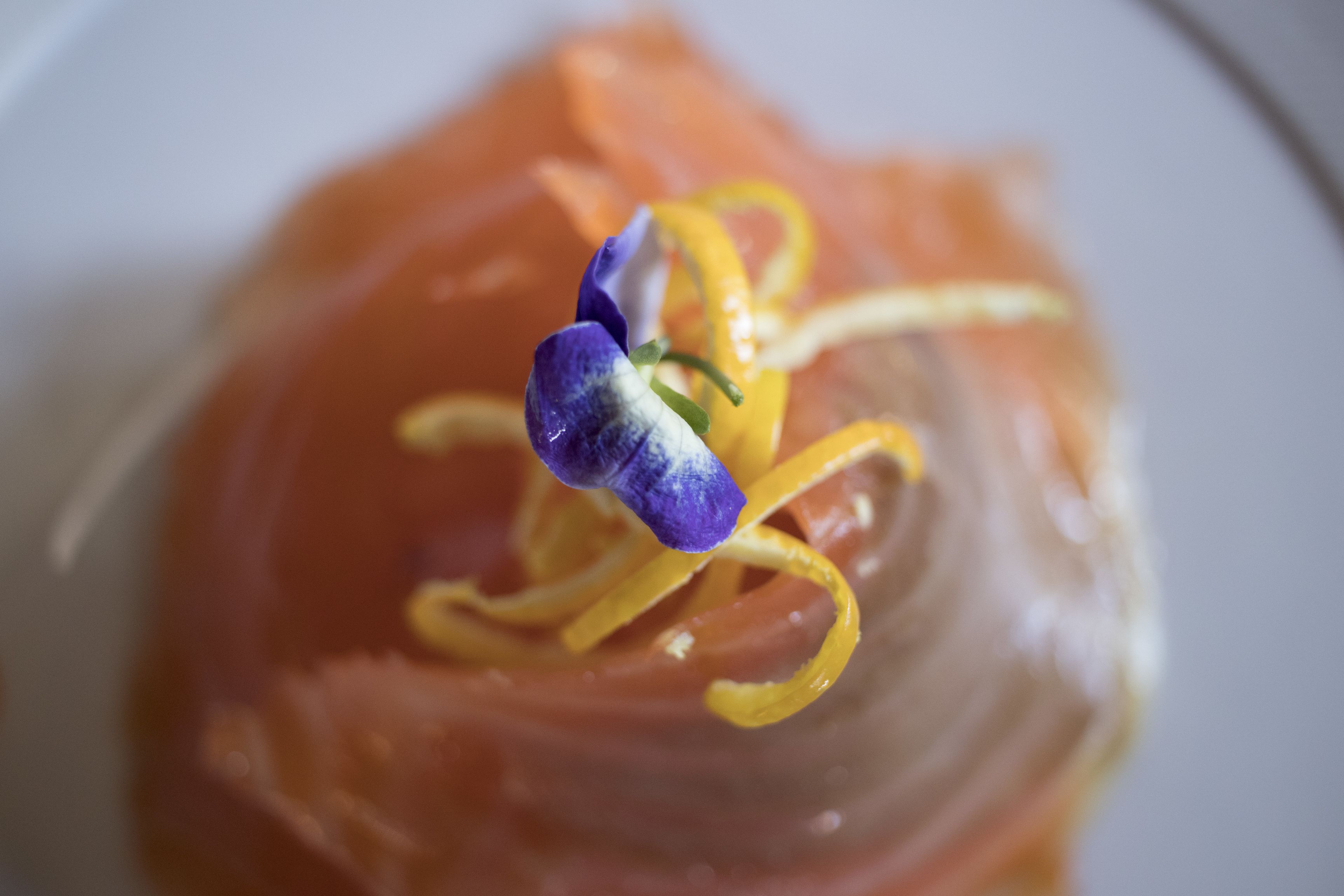 A close-up of a dish with salmon and a decorative element.
